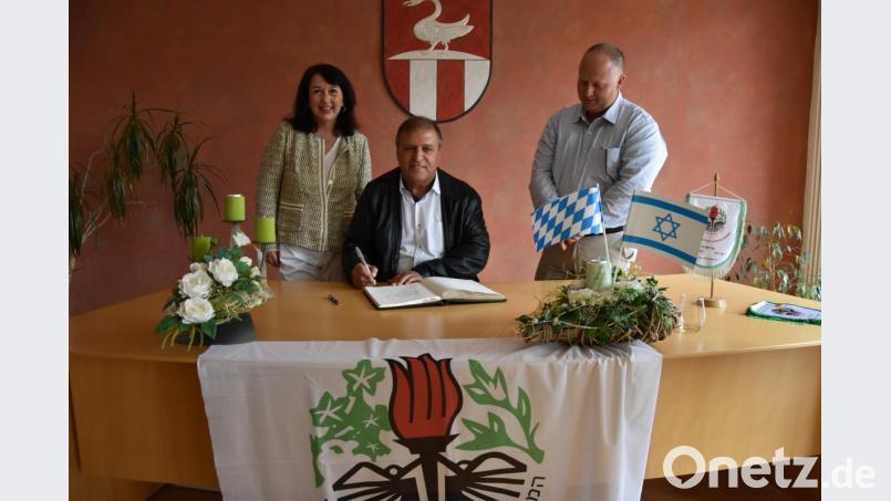 Der Bürgermeister der israelischen Partnergemeinde, Shimon Susan (Mitte), trägt sich ins Goldene Buch ein. Weil der Gast nur Hebräisch spricht, helfen Ammerthals Bürgermeisterin Alexandra Sitter (links) und ein Delegationsmitglied. Bild: Tobias Gräf