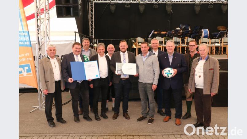 Kreisehrenamtsbeauftragter Christoph Kellner übergibt das Gütesiegel für 15 Jahre herausragende Vereinsarbeit an den 1. FC-Vorstand Hans Fischer (Bildmitte). Weiter v. l. Ehrenmitglied Gotthard Färber, BFV-Kreisvorsitzender Albert Kellner, Vereinsehrenamtsbeauftragter Richard Weigert, Josef Weinfurtner, Gerhard ‚Schnabel (2. und 3. Bürgermeister), MdL Harald Schwartz, Landrat Richard Reisinger, Moderator Daniel Auer und Ehrenvorstand Jochen Ernst. Bild: riw