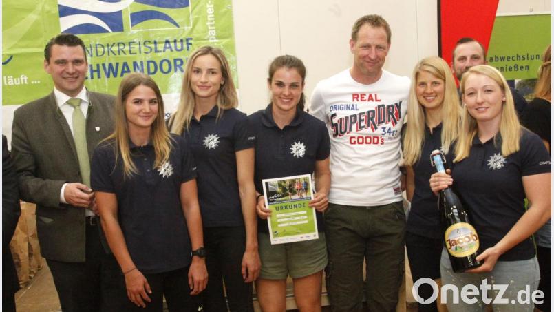 Schirmherr Landrat Thomas Ebeling (links) und Organisator Christian Meyer beglückwünschten die Läuferinnen der Bereitschaftspolizei Nabburg zum dritten Platz in der Damenwertung. Bild: Hirsch