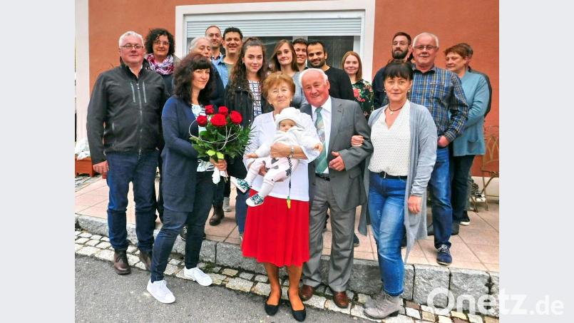 Sechs rote Rosen gibt es für Mathilde Olischer (vorne Mitte) zur diamantenen Hochzeit. Das größte Geschenk für sie und ihren Mann Josef (rechts daneben) ist aber Urenkeltochter Emilia. Bild: hai