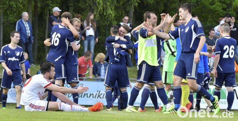 Inmitten der sich freuenden Ettmannsdorfer sitzt Bergsteig-Kapitän Albert Sejdiu (links) enttäuscht auf dem Rasen. Bild: Hubert Ziegler