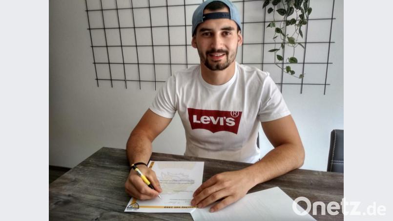 Martin Brabec setzt seine Unterschrift unter den Vertrag mit dem ERSC Amberg. Die Löwen-Verantwortlichen freuen sich auf den Top-Stürmer – und die Fans können das auch. Bild: pa