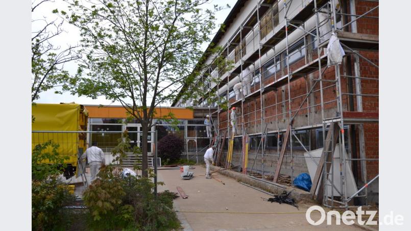 Mit dem Abriss der Fassadenverkleidung begannen die Sanierungsarbeiten an der Grundschule Moosbach. Wegen des asbesthaltigen Materials mussten die Arbeiter eine entsprechende Schutzkleidung tragen. Bild: gi