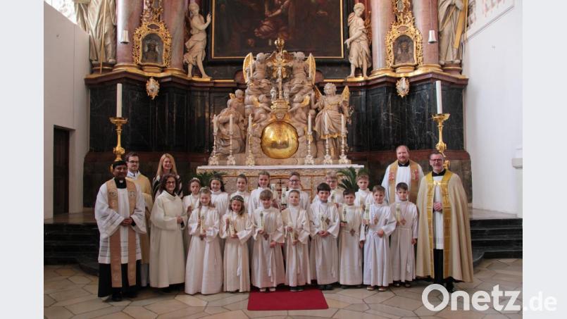 Die Erstkommunionkinder der Klasse 3 a mit (von rechts) Stadtpfarrer Thomas Vogl und Pfarrvikar Markus Hochheimer und (von links) Pater John, Diakon Frater Gregor Schuller OSB, Gemeindereferentin Gertrud Hankl und der Leiterin der Grundschule, Karin Gleißner. Bild: exb