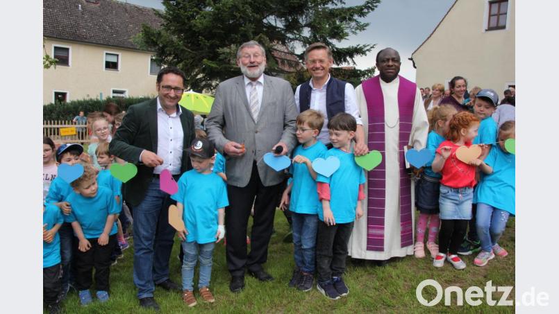 Freie-Wähler-Landtagsabgeordneter Tobias Gotthardt, Bürgermeister Josef Schmidkonz, CSU-Landtagsabgeordneter Tobias Reiß und Pfarrer Charles Ifemeje (von links) durchschnitten das Band zum neuen „Garten der Freundschaft“. Die Kindergartenkinder assistierten. Bild: kro