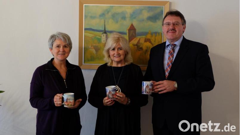 Adolfine Nitschke (links) und Bürgermeister Hans-Martin Schertl nehmen die neuen Tassen entgegen, die Künstlerin Christina Hausmann (Mitte) gestaltet hat. Bild: Stefanie Gradl