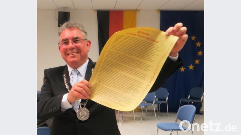 Bürgermeister Norbert Bücherl präsentiert den „Bergwerksleuten“ die verliehene Freiheitsurkunde. Bild: nbu