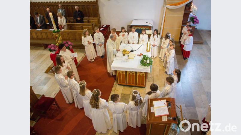 Um erstmals die Kommunion zu empfangen, versammelten sich die 20 Kinder mit Stadtpfarrer Hans-Peter Bergmann und Gemeindereferentin Barbara Schlosser um den Altar. Bild: u