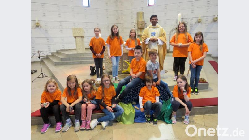 Pfarrer Augustin Lobo (Mitte) und der Kindersingkreis beeindrucken beim Familiengottesdienst mit Liedern und dem Predigtspiel „Die Kinderbrücke“. Bild: lep