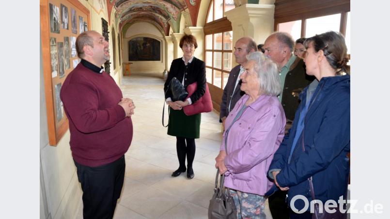 Isabelle Lütz, eine geborene Prinzessin zu Löwenstein-Wertheim-Rosenberg (im Hintergrund), vernimmt interessiert die von Pfarrer Miroslav Matis (links) im Kreuzgang gegebenen Informationen. Bild: fjo