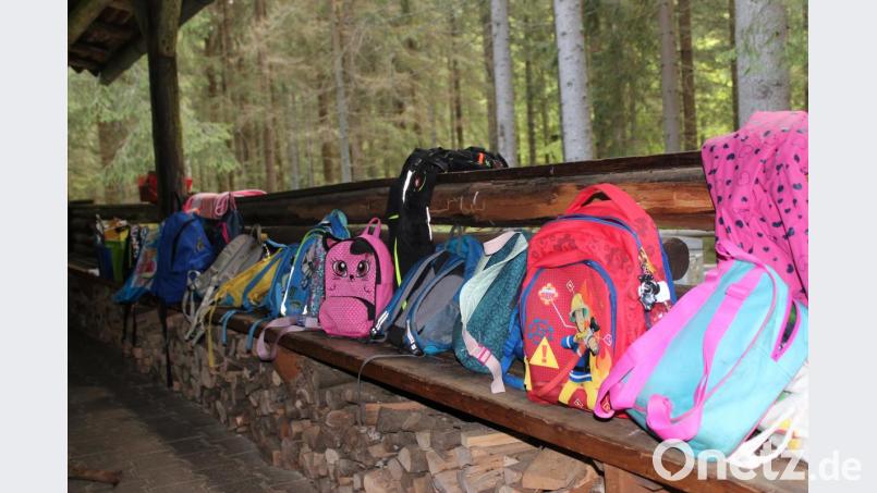 Viele bunte Rucksäcke reihen sich auf der Terrasse der Blockhütte. Bild: Susanne Forster