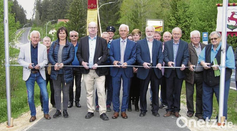 Zahlreiche Ehrengäste inklusive Baudirektor Berthold Schneider (vorne, Dritter von links) und Bürgermeister Peter König (Vierter von links) durchschnitten das obligatorische Band und gaben mit diesem symbolischen Akt den Weg nach Schwarzenreuth frei. Bild: öt