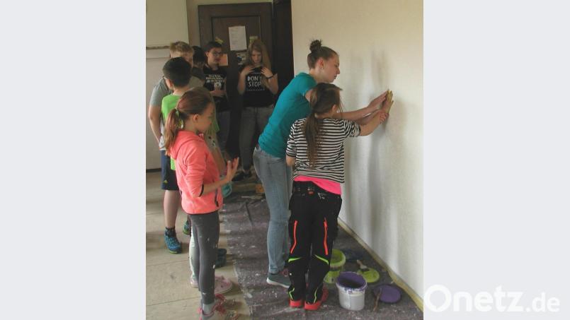 Unter Anleitung von Eva Glowka wurde die Absicht des Projekts, durch Engagement für andere, dem Glauben &quot;Hand und Fuß&quot; zu geben, im wahrsten Sinne des Wortes in die Tat umgesetzt: Handstempel an die Wand! Bild: ld