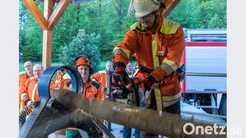 Wolfgang Voit, stellvertretender Kommandant der Feuerwehr Fichtelberg, übt unter Anleitung durch Forstwirtschaftsmeister Korbinian Scherm von den Bayerischen Staatsforsten das gefahrlose Durchtrennen eines gespannten Baumstämmen an einem Spannungssimulator. Bild: exb