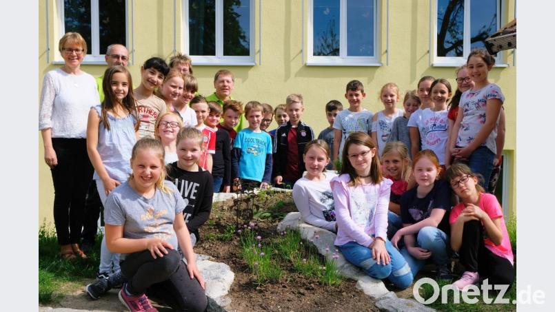Umringt von den begeisterten Viertklässlern übergeben Vorsitzender Josef Höllerl, seine Stellvertreterin Christine Walter und Vorstandsmitglied Hans Traßl im Namen des Obst- und Gartenbauvereins die Kräuter- und Gewürzschnecke an Schulleiterin Gabriele Bodner. Bild: do