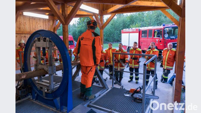Unter Anleitung durch Forstwirtschaftsmeister Korbinian Scherm von den Bayerischen Staatsforsten (Mitte) übten die Mitglieder der Feuerwehr Fichtelberg das gefahrlose Durchtrennen von gespannten Baumstämmen an einem Spannungssimulator. Bild: exb