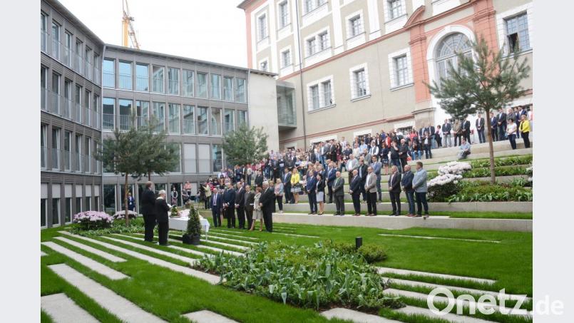Der Innenhof des Anbaus am Landratsamt ist das eigentliche Schmuckstück der neuen Immobilie. Die Ehrengäste diskutieren schon vor dem kirchlichen Segen der Pfarrer Josef Häring und Ulrich Gruber, was man in dem Halbrund alles veranstalten könnte. Bild: Gabi Schönberger