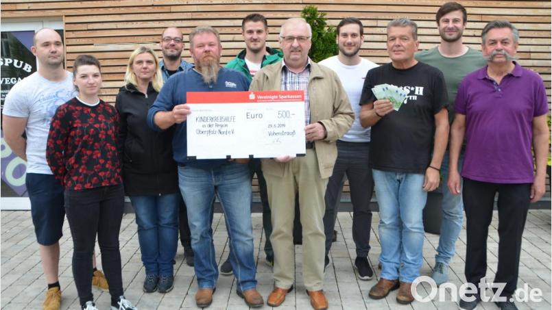 Rainer Schön (Fünfter von links) war mit seinem Sohn Dominik (nicht im Bild) Rädelsführer bei der spontanen Grillfete mit Freunden. Der Erlös in Höhe von 500 Euro geht nun an die Kinderkrebshilfe in der Region Oberpfalz Nord. Vorsitzender Herbert Putzer (Fünfter von rechts) nimmt die Spende entgegen. &quot;Las Vegas&quot;-Pilspub-Besitzer Peter Dirscherl (Dritter von rechts) zahlt gleich in bar. Bild: dob