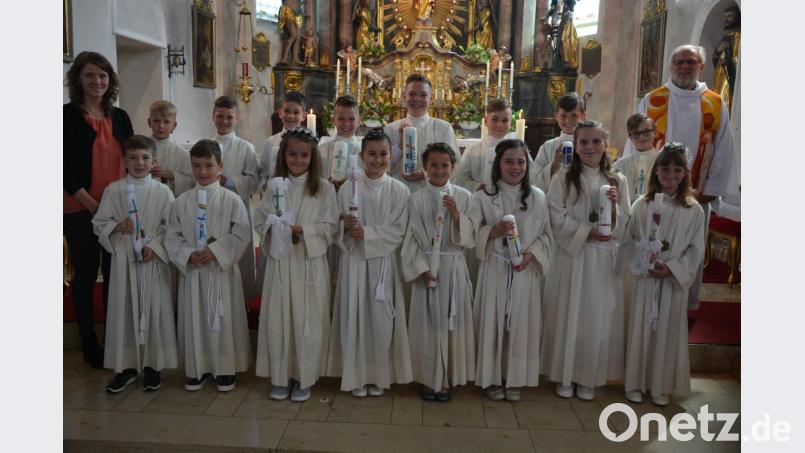 Die 16 Erstkommunikanten mit Pfarrseelsorger Pater Benedikt Leitmayr und Klassenleiterin Sandra Peterhans am Ende des Festgottesdienstes. Bild: jr