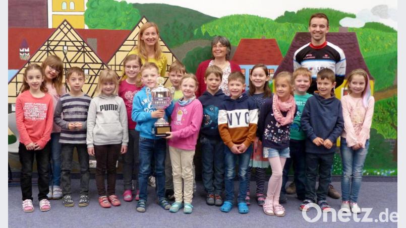 Die 1a der Grundschule Illschwang freut sich über den Wanderpokal und die Gummibärchen darin. Klasslehrerin Christine Schaffenroth (Mitte), Lauftreff-Leiter Andreas Dehling (rechts) und Lauftrainerin Carmen Grahlmann (links) überreichen die Trophäe für die Klasse mit den meisten Startern beim Kinderwaldlauf. Bild: no