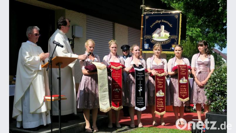 Pfarrer Peter Wolz (links) segnete die neue Standarte und die Bänder, die die Festdamen an die Fahne anhefteten. Bild: Hirsch