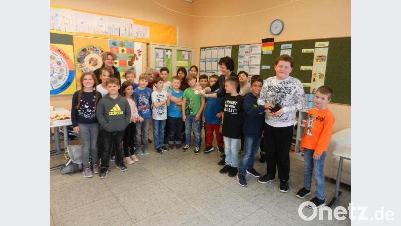 Rektorin Ulrike Neiser hält einen weißen Wuschelkopf in den Händen, während Simon Walberer den dunkelgefärbten &quot;Jonny&quot; behütet. Die Drittklässler versorgen seit einigen Wochen junge Kaninchen. Bild: nn
