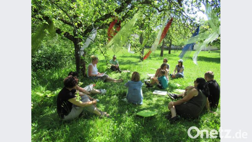 Alexandra Beyer liest unter dem Apfelbaum im hohen Gras ein romantisches Märchen vor. Bild: exb