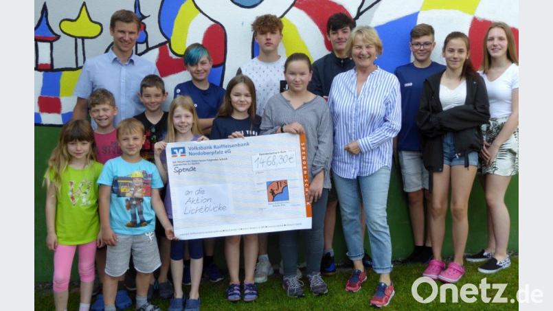 Die lauffreudigen Schüler der Josef-Faltenbacher-Schule mit stellvertretendem Schulleiter Matthias Werner (hinten links) übergeben die Spende an Elisabeth Wittmann, die Schirmherrin der Aktion „Lichtblicke . Bild: fsb