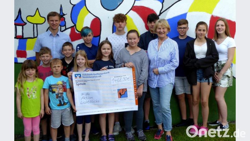 Die lauffreudigen Schüler der Josef-Faltenbacher-Schule mit stellvertretendem Schulleiter Matthias Werner (hinten links) übergeben die Spende an Elisabeth Wittmann, die Schirmherrin der Aktion „Lichtblicke . Bild: fsb