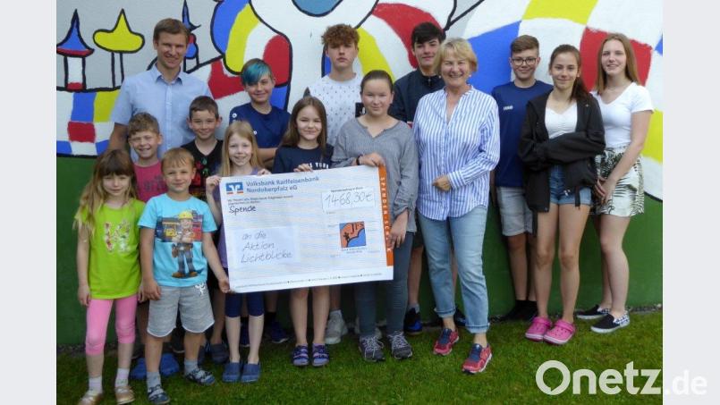 Die lauffreudigen Schüler der Josef-Faltenbacher-Schule mit stellvertretendem Schulleiter Matthias Werner (hinten links) übergeben die Spende an Elisabeth Wittmann, die Schirmherrin der Aktion „Lichtblicke . Bild: fsb