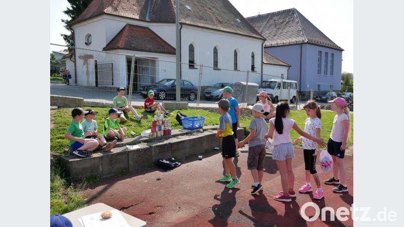 Mit dem Tennisball müssen die Schüler die Blechdosen umwerfen. Bild: gz