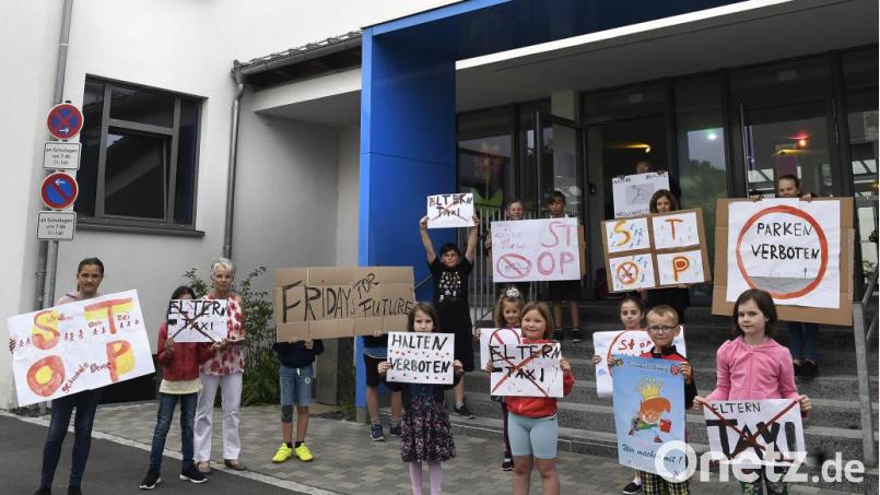 Die „Fridays for Future“-Demo an der Pestalozzischule findet schon vor Schulbeginn statt. Und sie richtet sich gegen Eltern, die ihre Kinder bis direkt vor den Haupteingang fahren. Bild: Petra Hartl