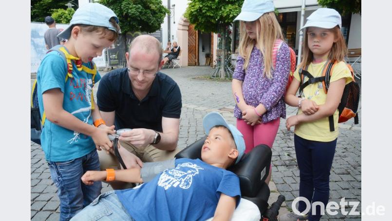 Auf der Rettungstrage des BRK bekommen die Kindergartenkinder und Grundschüler Einblicke in den Alltag von Sanitätern und Notärzten. Ziel ist, ihnen etwaige Berührungsängste zu nehmen, damit im Notfall keine Scheu zur Kontaktaufnahme besteht. Bild: Gabi Schönberger