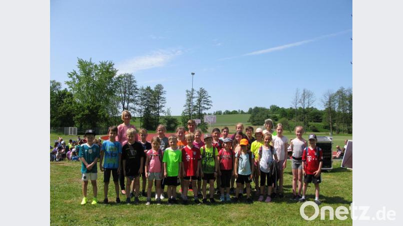 Rektorin Christine Wiesend (hinten links) und Sportlehrerin Birgit Emerig (hinten rechts) gratulieren den schnellsten Läufern beim Grundschul-Sportfest. Bild: jzk