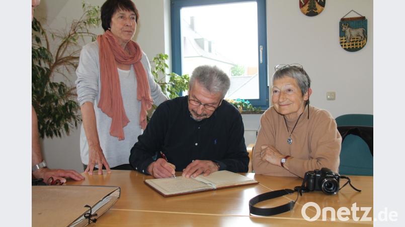 Die französichen Gäste Josette Arvieu, Wladislaw Panarin, Marie-José Panarin (von links) tragen sich ins Gästebuch von Thanstein ein. Bild: dl