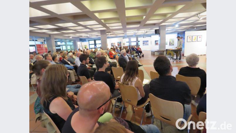 Zahlreiche Gäste nehmen an der Vernissage teil, die von Matthias Scholz am Vibraphon musikalisch begleitet wird. Bild: ubb