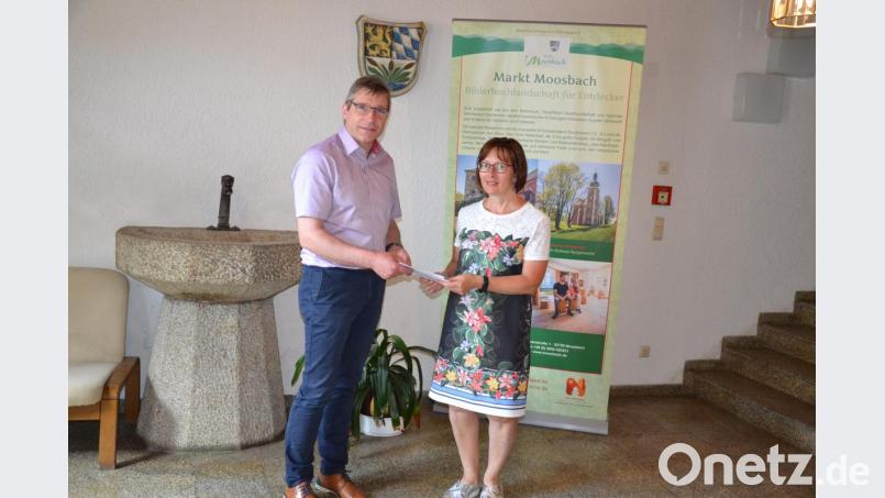 Die Leiterin der Gäste-Information Claudia Rieß überreichte ein druckfrisches Exemplar des Kinder-Spaß-Programms an Bürgermeister Hermann Ach. Bild: gi