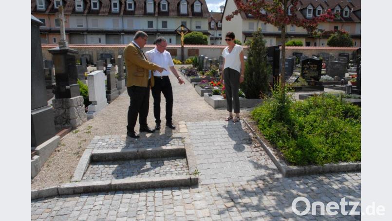 Bürgermeister Peter Braun (von links) und die Inklusionsbeauftragten Karl Bauer und Michaela Meyer am Friedhof. Hier konnte innerhalb kürzester Zeit ein Problem beseitigt werden. Die Wegeinfassung wurde teilweise abgesenkt. Dies erleichtert es, zu den Gräbern zu kommen. Bild: pop