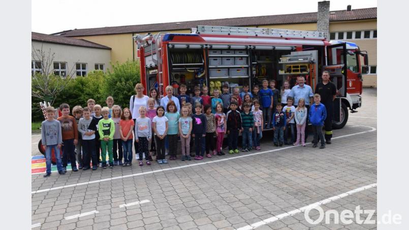 Wie setze ich einen Notruf ab? Was versteckt sich in einem Feuerwehrauto? Diese Fragen beantworteten Kreisbrandmeister Jürgen Ehrensberger und Feuerwehrmann Patrik Hauser den Schülern in Schmidmühlen. Bild: bö