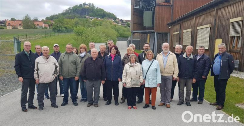 Die Teilnehmer beim Besuch der Firma Witron stehen vor der Seilbahn, die den Materialaustausch zwischen den Werken 3 und 4 regelt. Bild: adj