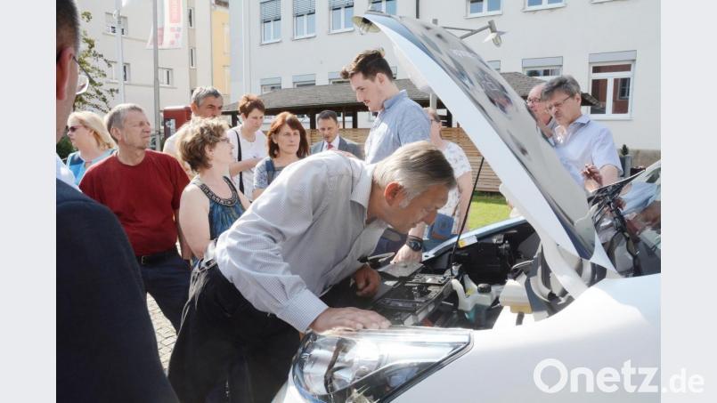 Als Ingenieur interessiert Grünen-Stadtrat Karl Bärnklau auch ein Blick unter die Motorhaube des Nissan e-NV200. Im Hintergrund gibt Jonathan Heise (Mikar) zahlreichen Interessierten, darunter auch Gisela Helgath (Grüne) Auskunft. Bild: Gabi Schönberger