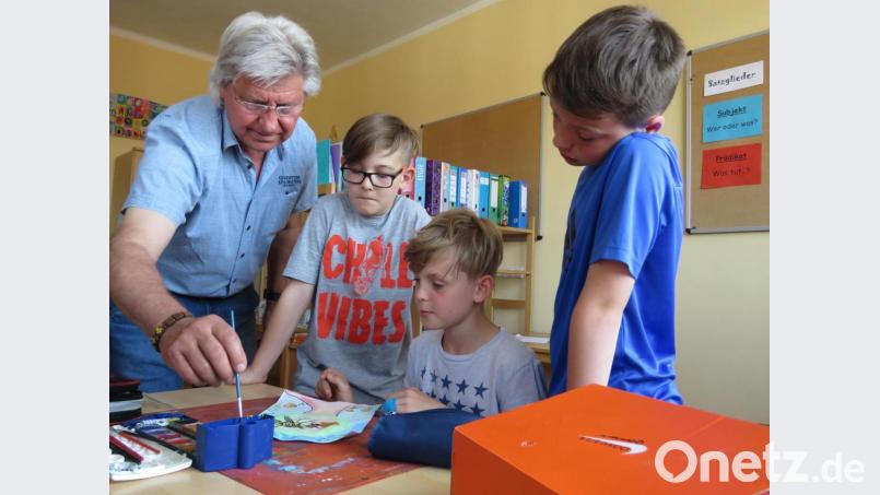 Künstler TomBrankovic hilft Noah, Dominik und Tim bei der Auswahl der passenden Farben. Bild: ubb