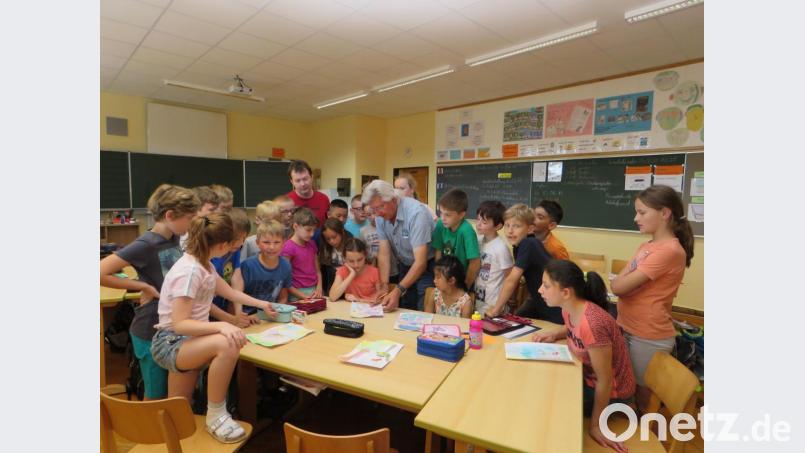 Tom Brankovic (Mitte) zeigt der Klasse 4a, wie mit den Farben richtig umgegangen wird. Lehrer Archim Neubauer (links) schaut zu. Bild: ubb