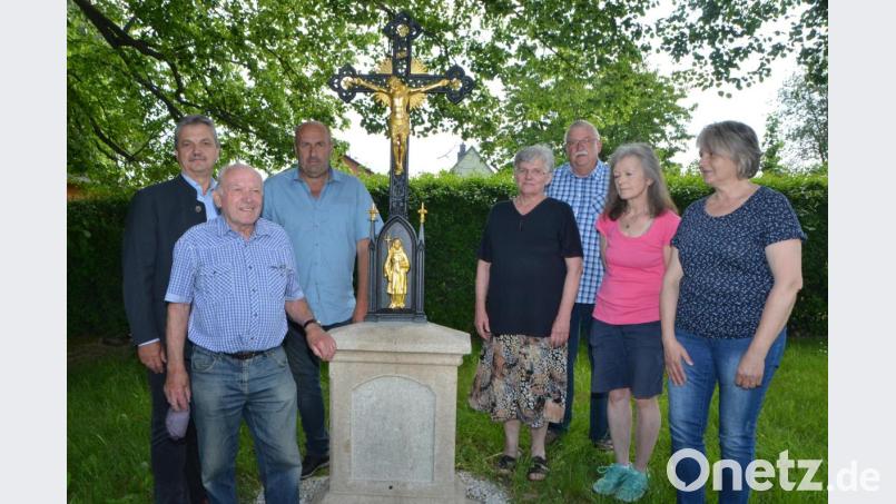 Waltraud Kick (rechts) erbte das Kreuz von ihrem Vater. Brigitte Kick (Zweite von rechts) hatte die zündende Idee, das Mahnmal in die Fronleichnamsprozession einzubinden und Elisabeth Ertl (Vierte von rechts) trug das Ansinnen ins Rathaus zu BÜrgermeister Andreas Wutzlhofer (links). Hans Oppelt und Außendienstleiter Karl Frey (Zweiter und Dritter von links) schlossen sich daraufhin mit Marterl-Experte Rudolf Großmann (Dritter von rechts) für die Erneuerung zusammen . Bild: dob