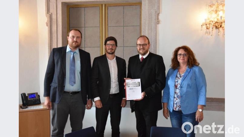 Sören Patzack (Zweiter von links) von der Firma BET aus Aachen überreicht Landrat Andreas Meier (Zweiter von rechts) das neue &quot;E-Mobilitätskonzept&quot; für den Landkreis. Sachgebietsleiterin Barbara Mädel und Stefan Härtl aus der Abteilung Wirtschaftsförderung zeigen sich von dem Projekt überzeugt. Bild: Tobias Gräf
