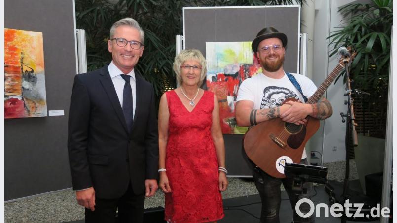 Vorstandsvorsitzender Werner Heß (links) begrüßte Künstlerin Irene Ehemann (Mitte) und Musiker Ben Stone (rechts) zur Ausstellungseröffnung in der Sparkasse. Bild: Hirsch