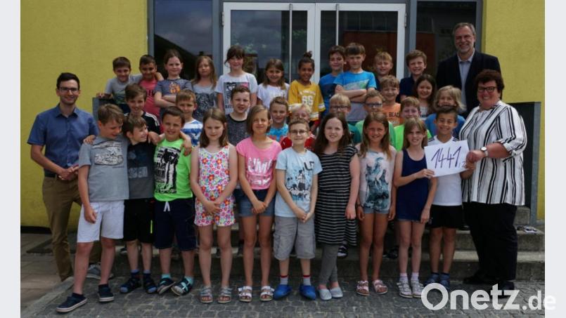 Pfarrer Josef Irlbacher (hinten rechts) und Pastoralassistent Andreas Hornauer (vorn links) freuen sich mit den Kommunionkindern über die Rekordsumme bei der Aktion „Spenden statt Gegengeschenke“, die sie an Karin Borchers (vorn rechts) vom Team der spezialisierten ambulanten pädiatrischen Palliativversorgung (SAPPV) übergeben. Bild: ads