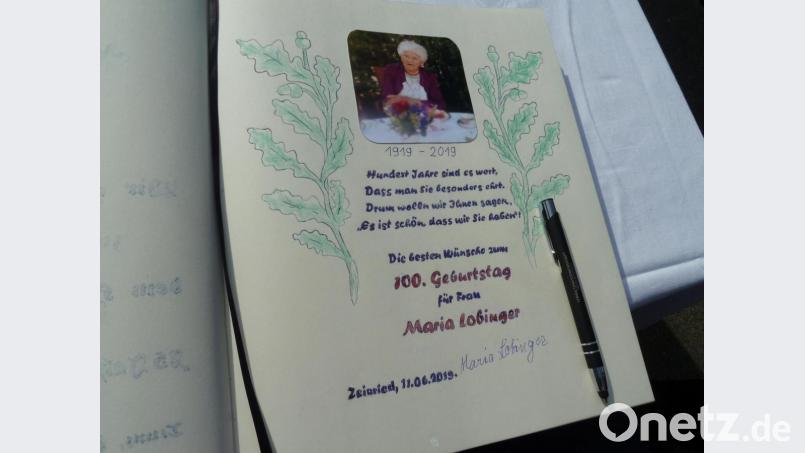 Respekt: Ohne Brille leistete Maria Lobinger ihre Unterschrift unter dem Eintrag in das Goldene Buch der Gemeinde Teunz. Bild: Portner