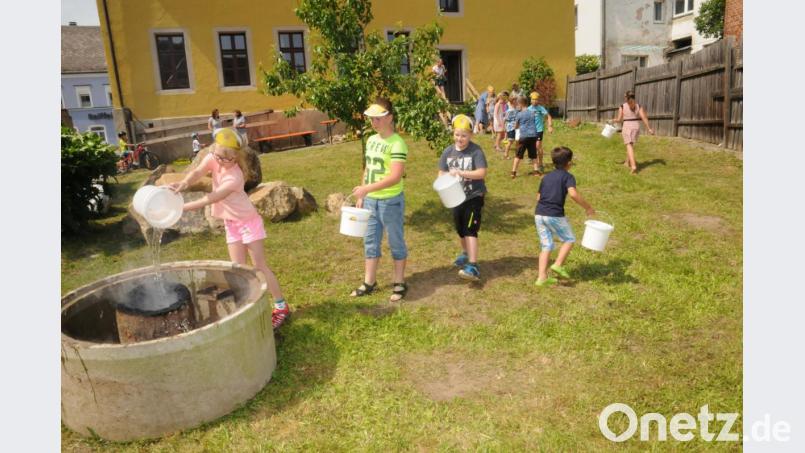Per Eimerkette durften die Kinder ein &quot;wohlbehütetes&quot; Feuer im Museumsgarten löschen. Bild: bey