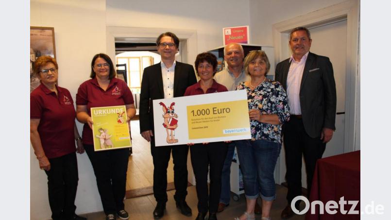 Mit der Urkunde überreicht der Kommunalbetreuer Ostbayern des Bayernwerks, Markus Windisch (Mitte), den Scheck über 1000 Euro an Büchereileiterin Claudia Schnödt. Mit im Bild von rechts Bürgermeister Joachim Neuß, Gerda Hörmann, Georgine Biersack und Barbara Lord. Männliche Verstärkung erhält das Damenteam der Stadtbücherei seit kurzem durch Winfried Schnödt. Bild: cs